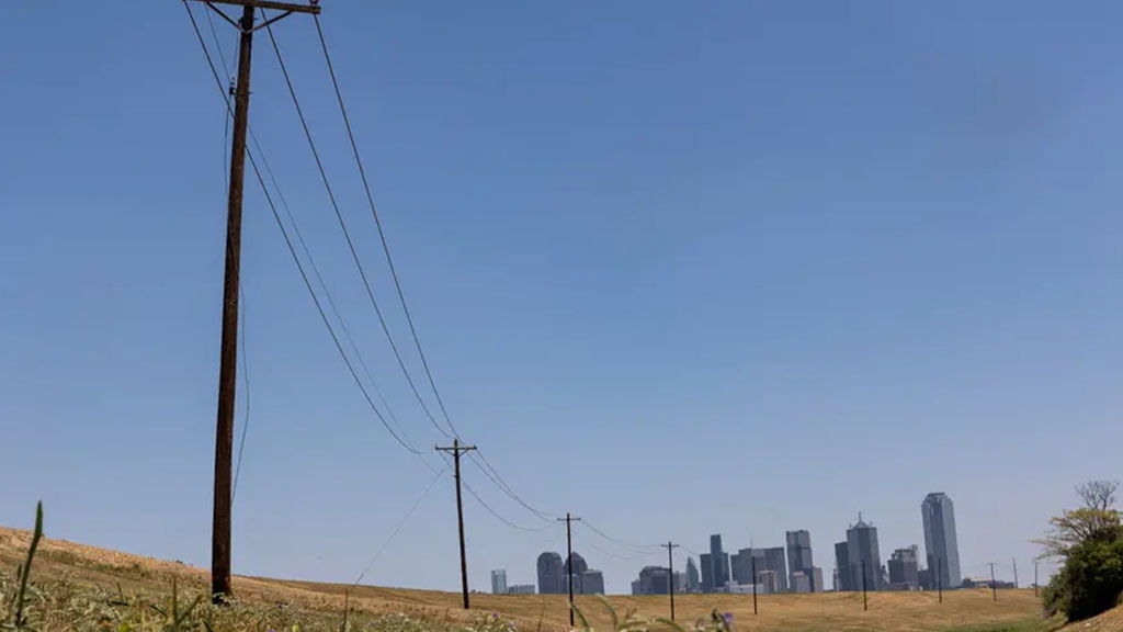 Utility poles lead to downtown Dallas. The state’s energy grid operator asked Texans to voluntarily reduce their energy use Wednesday due to scorching temperatures and rising demand.