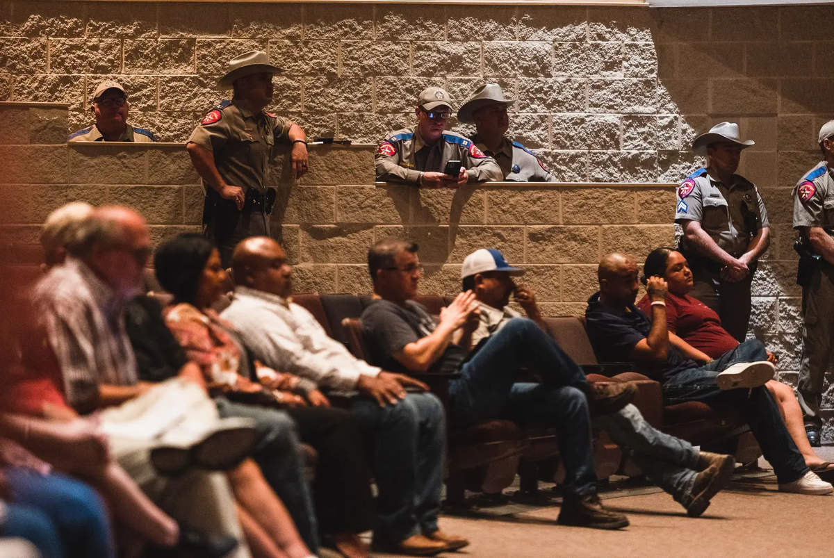 Texas Department of Public Safety officers stand near Uvalde residents at a heated school board meeting Monday night. Parents heavily criticized school officials about school safety and the district police department’s response to the May 24 shooting at Robb Elementary.