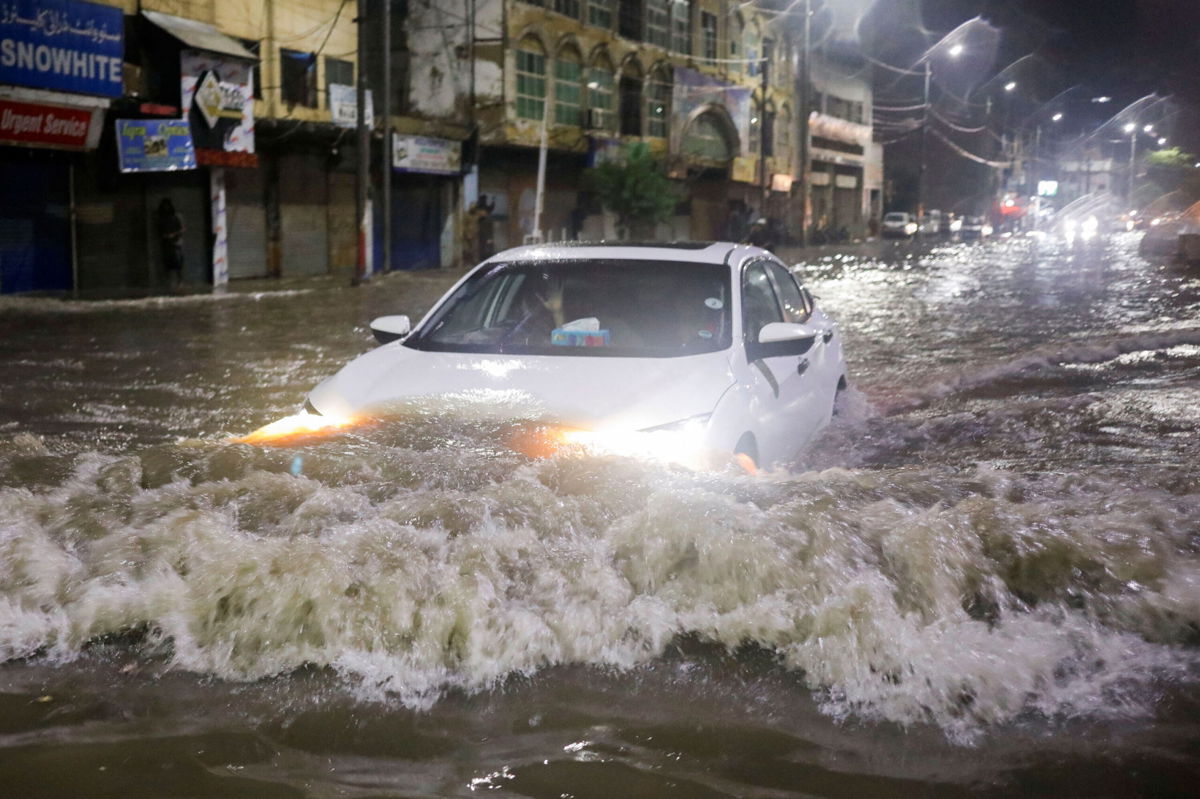 <i>Akhtar Soomro/Reuters</i><br/>A vehicle drives along a flooded street following heavy rains during the monsoon season in Karachi