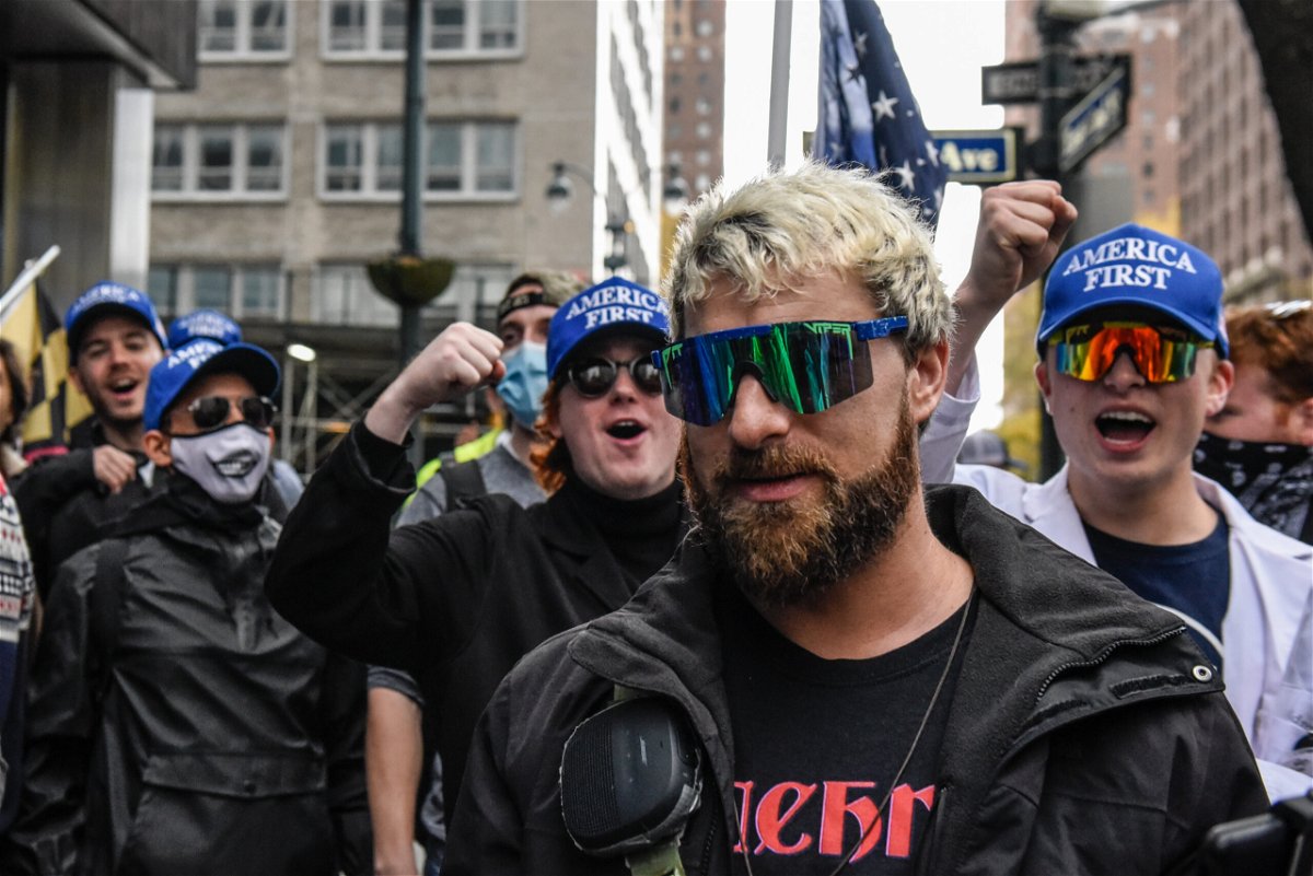 <i>Stephanie Keith/Getty Images</i><br/>Far right livestreamer Baked Alaska (C) is cheered on by people associated with the far-right group America First in front of Pfizer world headquarters on November 13