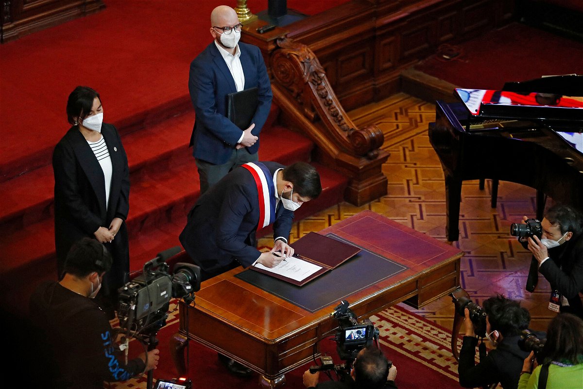 <i>Javier Torres/AFP/Getty Images</i><br/>President Boric signing the proposal.