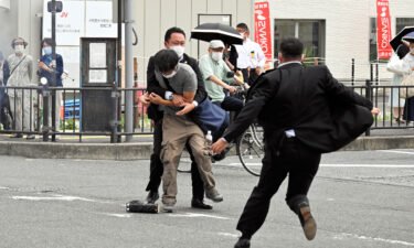 Security police tackle to arrest a suspect who is believed to have shot former Prime Minister Shinzo Abe in front of Yamatosaidaiji Station on July 8