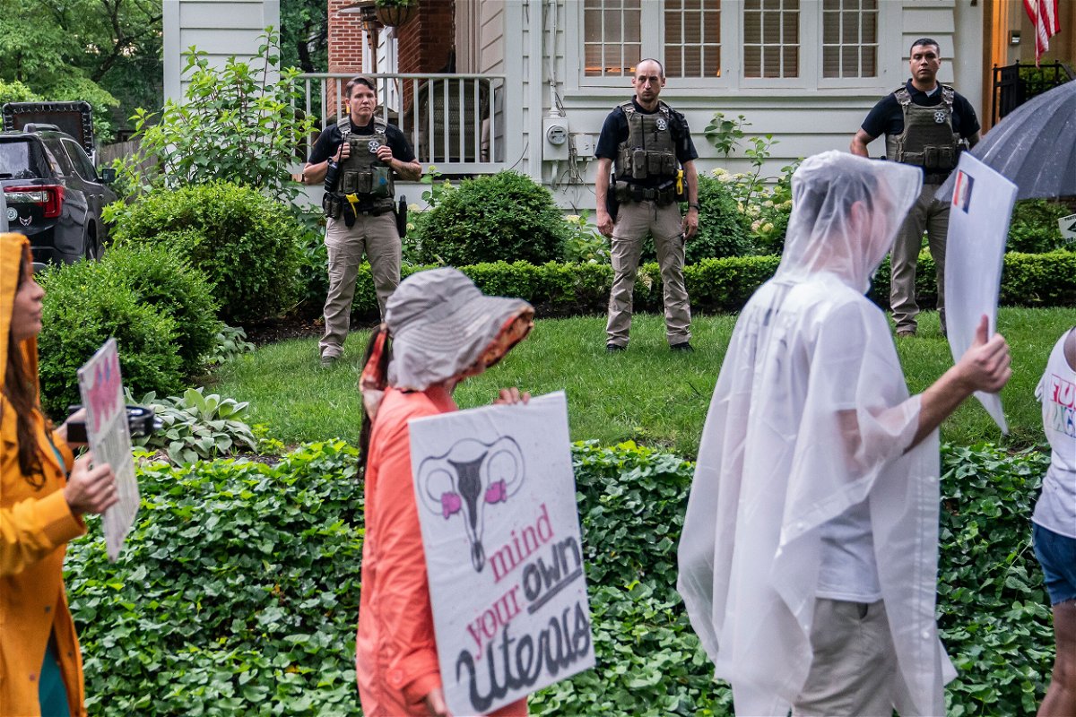 <i>Nathan Howard/Getty Images</i><br/>Protesters march past Supreme Court Justice Brett Kavanaugh's home on June 8. The Montgomery County Police says it will begin enforcing a Maryland law against disturbing the peace after more than two months of regular protests outside the homes of US Supreme Court justices.
