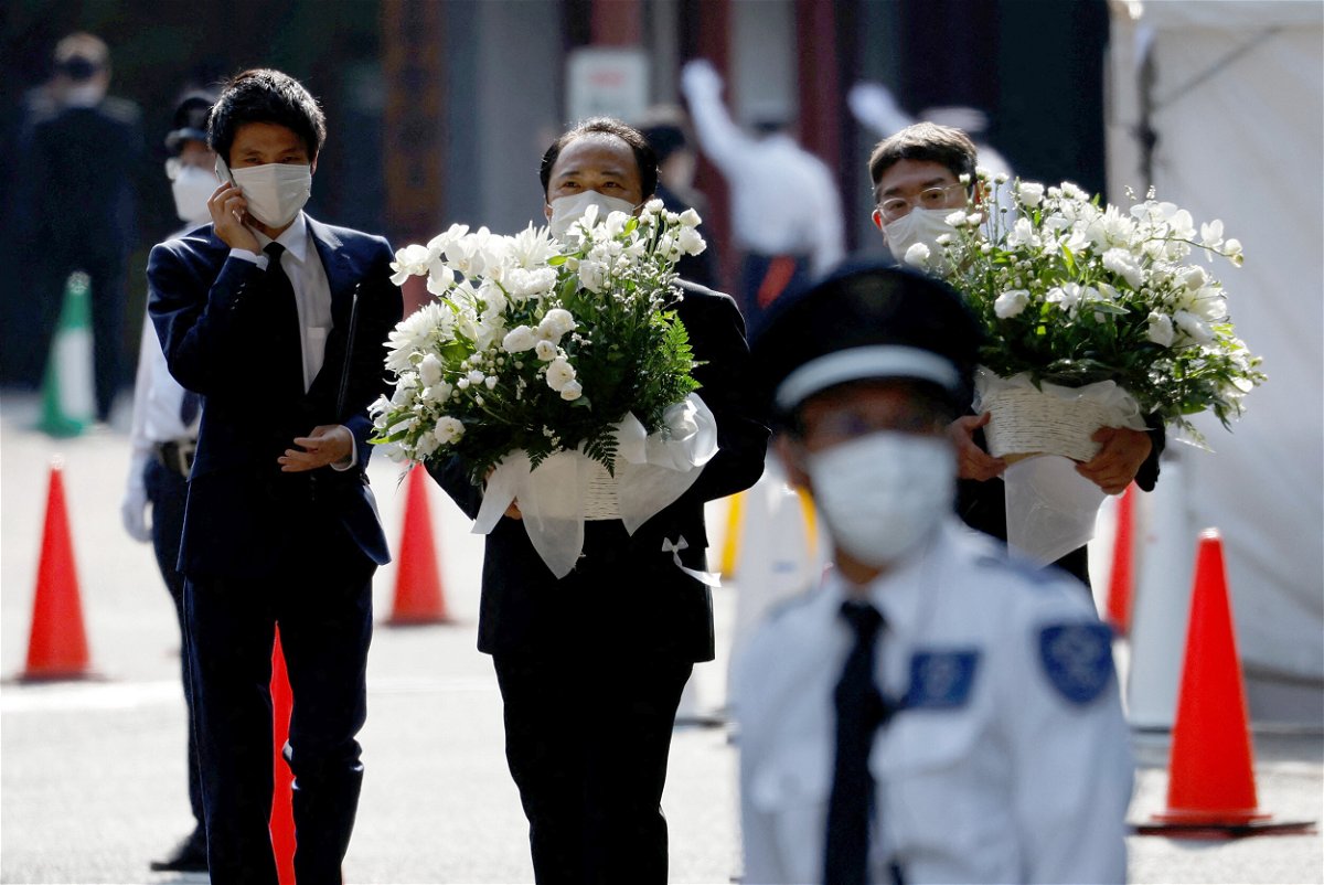 <i>Issei Kato/Reuters</i><br/>Officials carry flowers inside Zojoji Temple