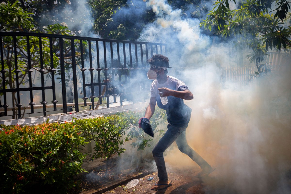 <i>Abhishek Chinnappa/Getty Images</i><br/>A protester runs for cover from a tear gas canister during a protest in Colombo