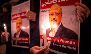 People hold posters picturing Saudi journalist Jamal Khashoggi and lightened candles during a gathering outside the Saudi Arabia consulate in Istanbul