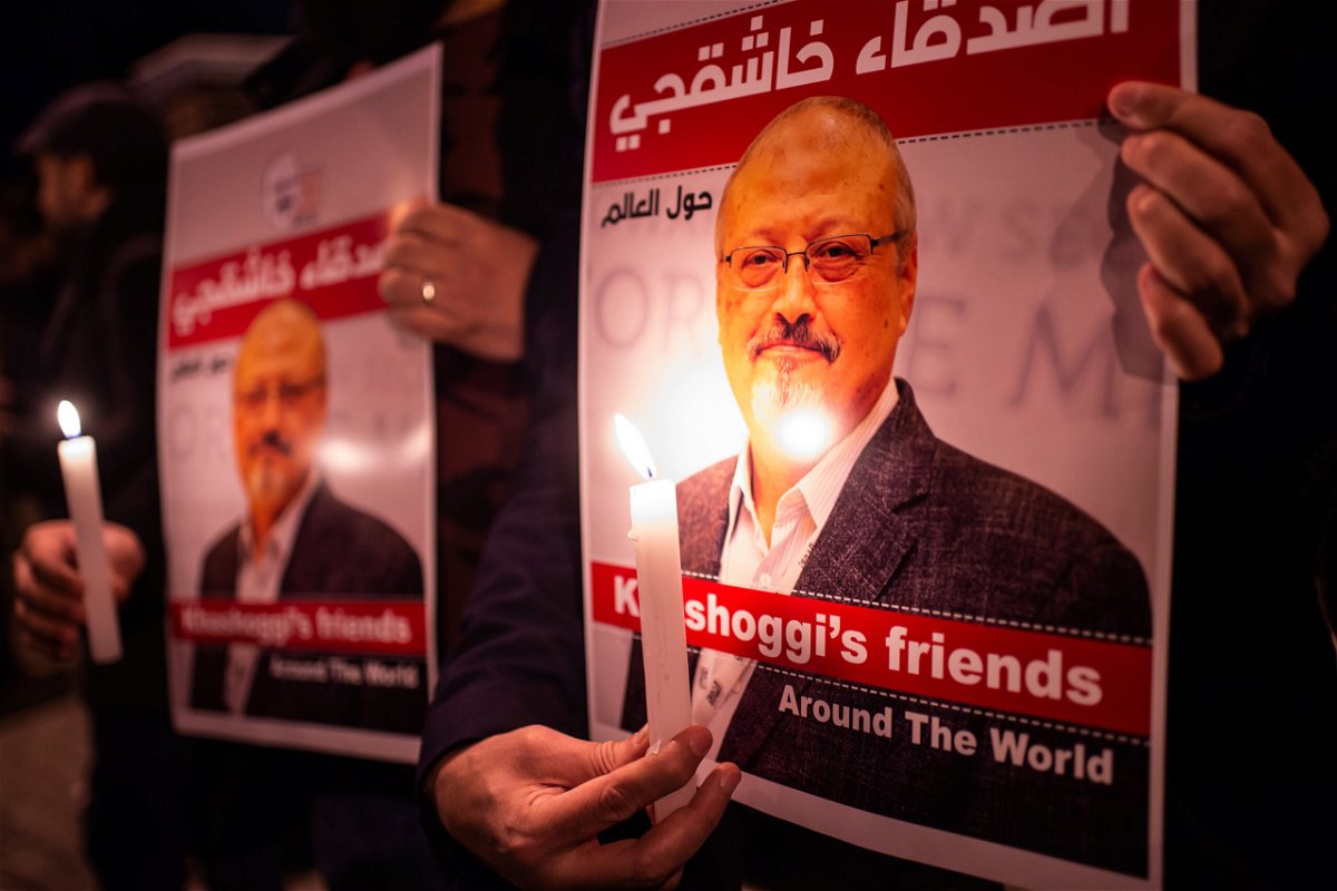 <i>Yasin Akgul/AFP/Getty Images</i><br/>People hold posters picturing Saudi journalist Jamal Khashoggi and lightened candles during a gathering outside the Saudi Arabia consulate in Istanbul