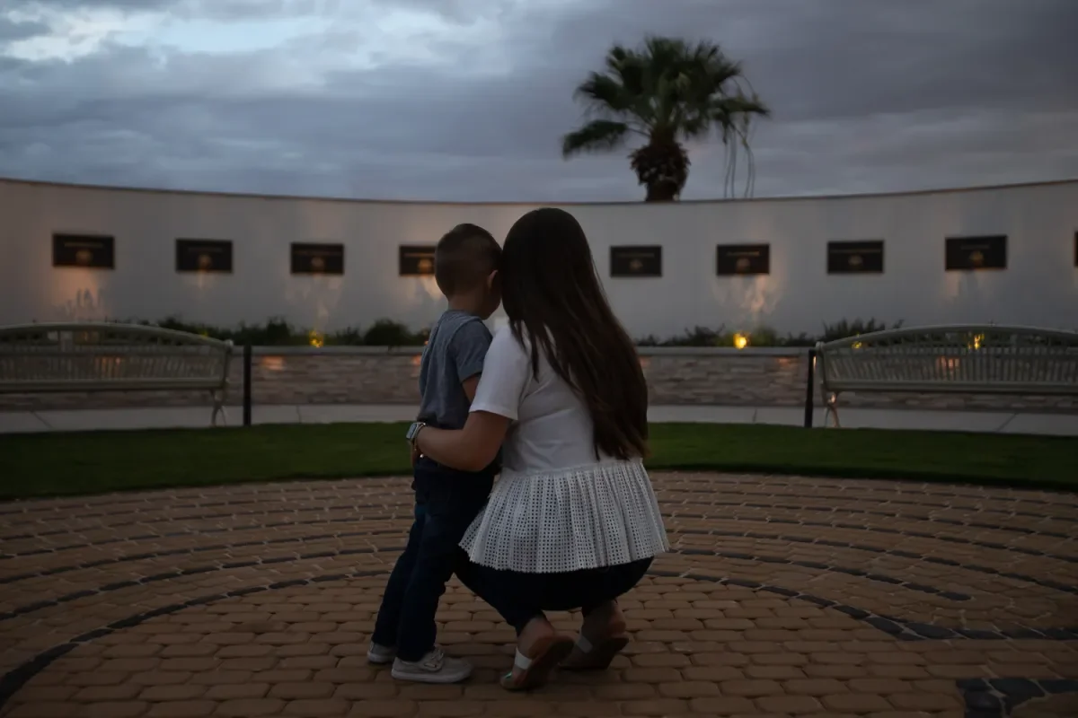 Jamie hugs her son, Julian, as they visit the El Paso County Healing Garden at Ascarate Park for the first time on July 27. Jamie worked at a bank inside Walmart in 2019 and witnessed the shooting just weeks before Julian was born.
