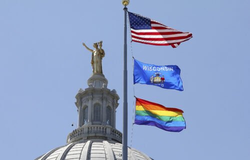 A rainbow flag observing Pride Month is displayed over the east wing of the Wisconsin State Capitol in Madison