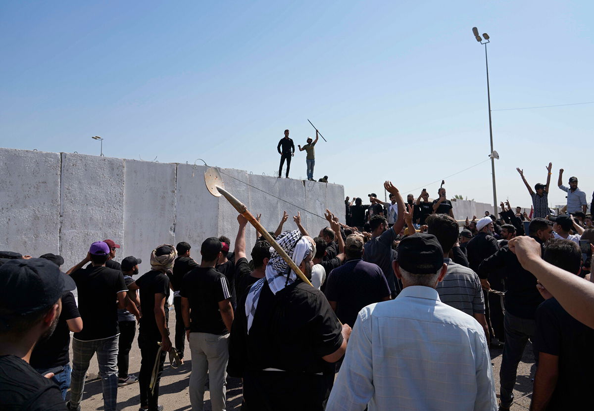 <i>Hadi Mizban/Associated Press</i><br/>Supporters of Muqtada al-Sadr try to remove concrete barriers in the Green Zone area of Baghdad on August 29.