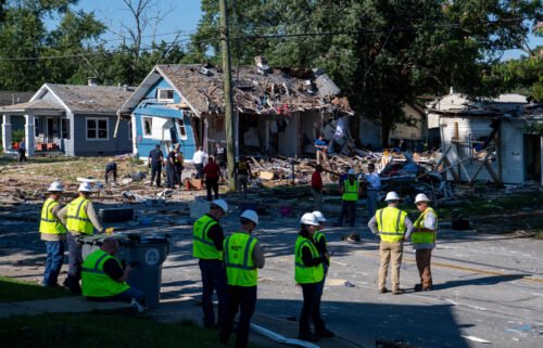 Emergency personnel search the debris left behind by an August 11