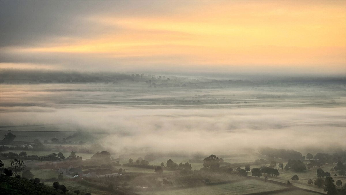 <i>Matt Cardy/Getty Images</i><br/>The rising sun tries to break through the mist near the town of Glastonbury in southwest England on fall equinox 2021.