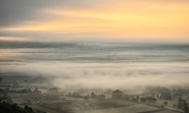 The rising sun tries to break through the mist near the town of Glastonbury in southwest England on fall equinox 2021.