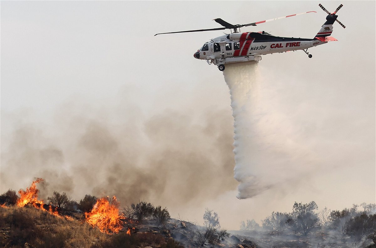 <i>Mario Tama/Getty Images</i><br/>A firefighting helicopter drops water as the Fairview Fire burns on September 7 near Hemet
