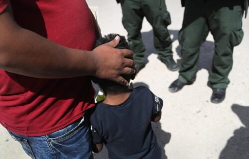 U.S. Border Patrol agents take a father and son from Honduras into custody near the U.S.-Mexico border in June 2018. The Justice Department wants a federal judge to require psychological examinations of families separated at the US-Mexico border.