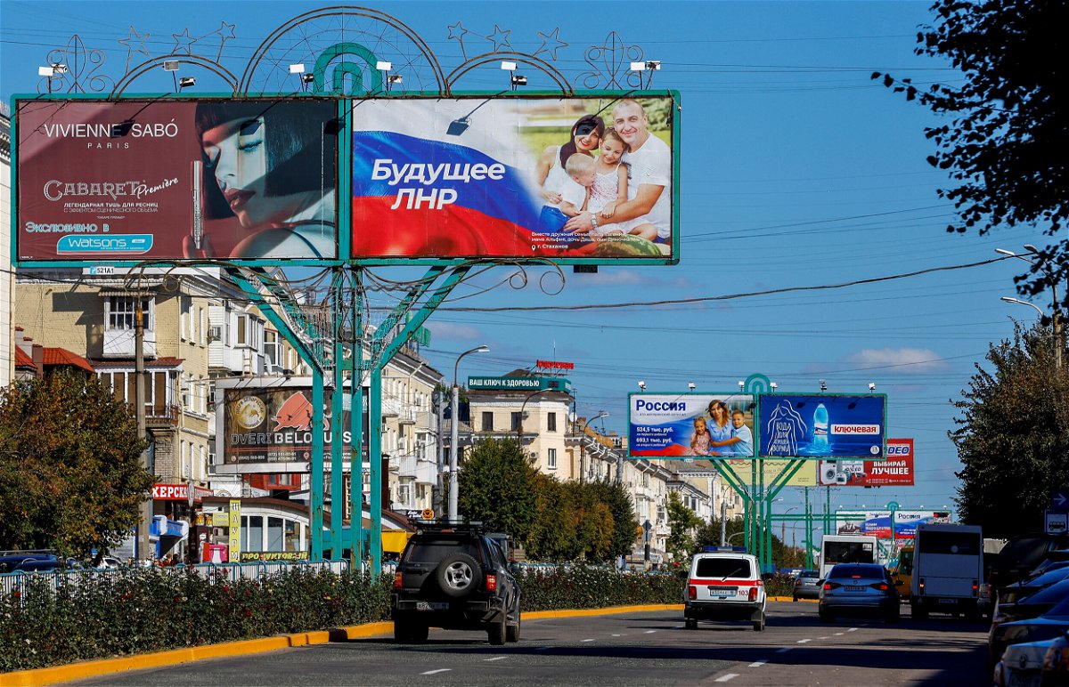 <i>Alexander Ermochenko/Reuters</i><br/>Vehicles drive past advertising boards displaying pro-Russian slogans in a street in Luhansk