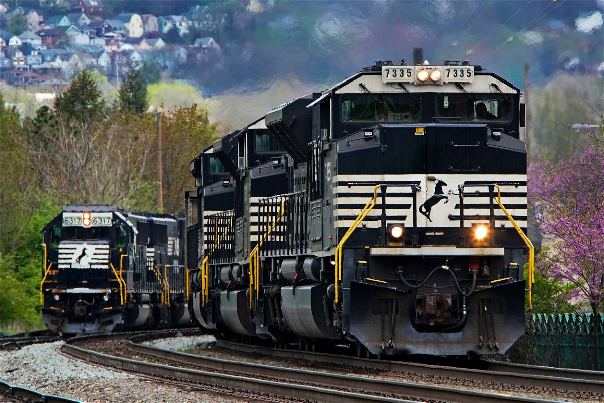 <i>Gene J. Puskar/AP</i><br/>A Norfolk Southern freight train passes a train on a siding as it approaches a crossing in Homestead