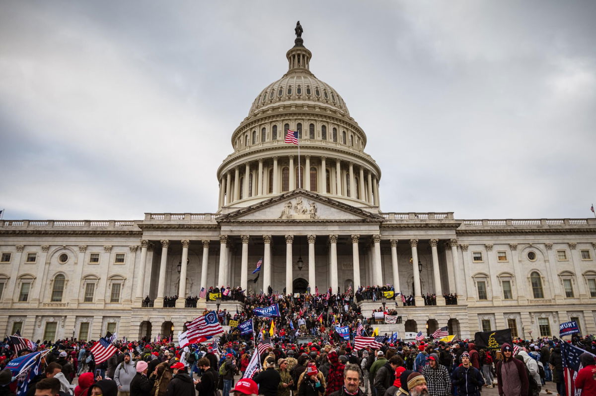 <i>Jon Cherry/Getty Images</i><br/>A large group of pro-Trump protesters stand on the East steps of the Capitol Building after storming its grounds on January 6