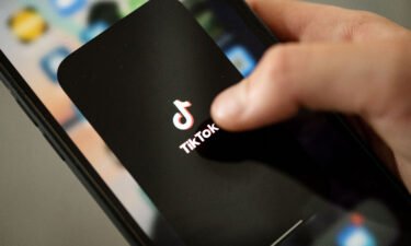 A teenager taps the TikTok logo on a smartphone. A research report this week says nearly 20% of videos presented by TikTok's search engine contain misinformation on topics ranging from Covid-19 to the January 6