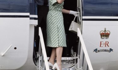 Queen Elizabeth II leaves Fiji during her royal tour on February 1977. Prince Philip is just visible behind her.
