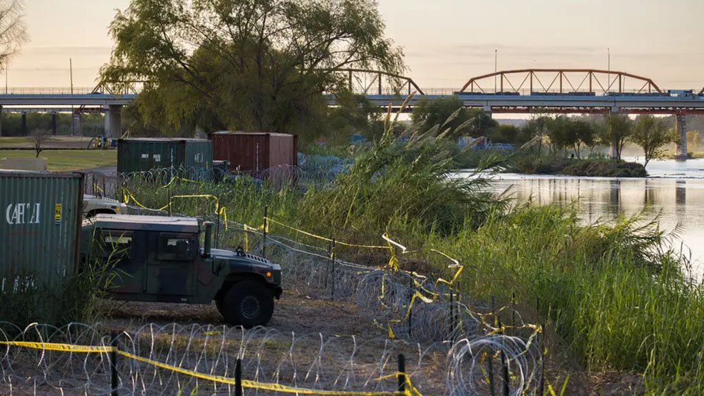 A row of shipping containers and razor wire on the banks of the Rio Grande was ordered by Gov. Greg Abbott to form a makeshift border wall in Eagle Pass on Nov. 19, 2021.
