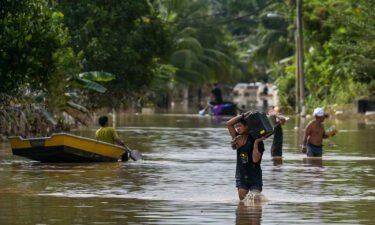 Residents walk through floodwaters in Malaysia's Pahang state in January 2021.