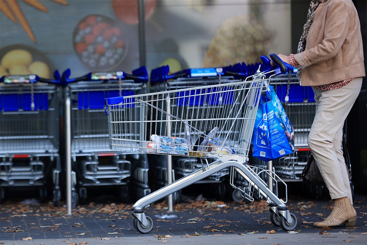 <i>Krisztian Bocsi/Bloomberg/Getty Images</i><br/>A customer pushes a shopping cart and bags outside a supermarket operated by Aldi Einkauf GmbH & Co.