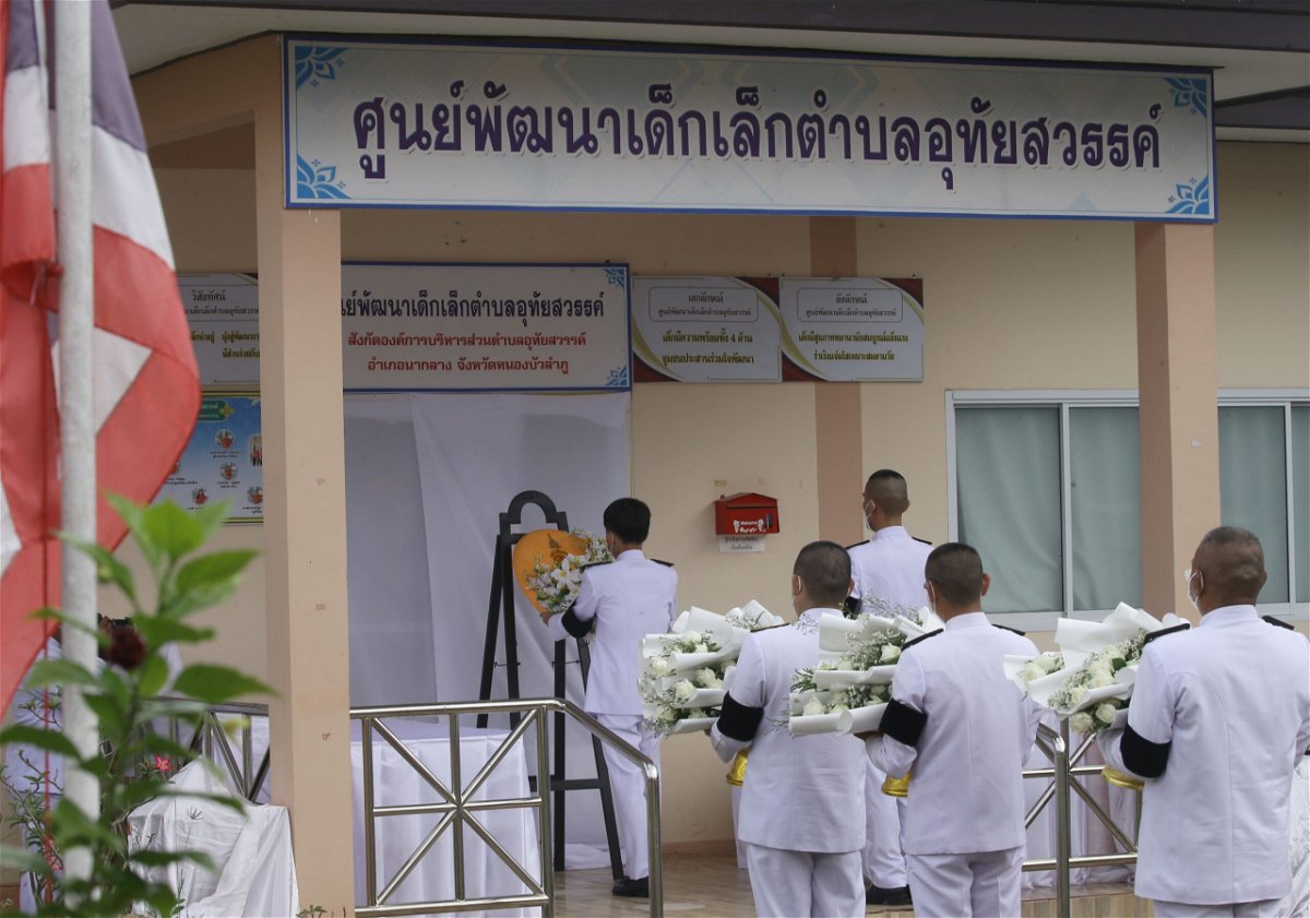 <i>Narong Sangnak/EPA-EFE/Shutterstock</i><br/>A Thai officer lays a wreath of flowers from the royal family to mourn those killed at a child care center in the country's north.