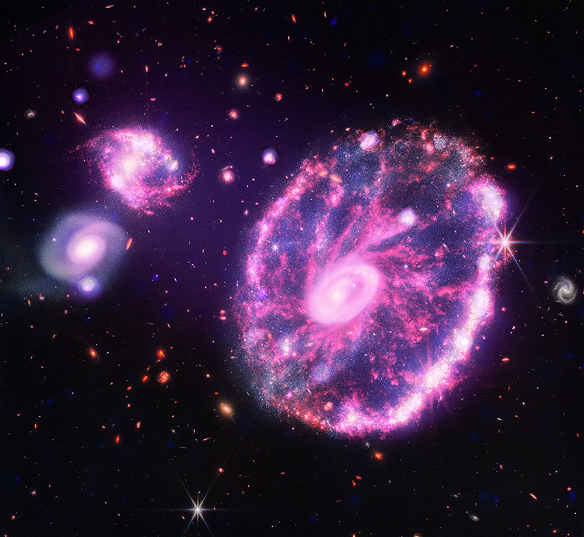 <i>NASA</i><br/>Chandra's X-ray data contributed to the glows in the Webb telescope's image of the Cartwheel galaxy.