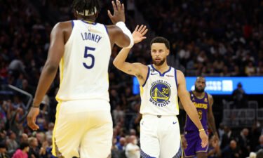 Curry high-fives Kevon Looney during the third quarter of the game against Lakers on Tuesday.
