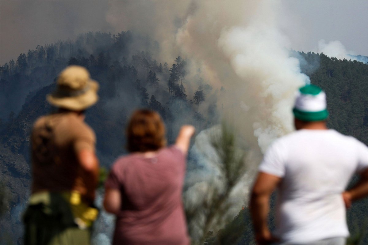 <i>Eliseo Trigo/EPA-EFE/Shutterstock</i><br/>Europe is warming faster than any other region. Residents watch as a column of smoke emerges from a forest fire in Galicia