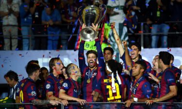 Piqué lifts the Champions League trophy after Barcelona won the competition in 2015.