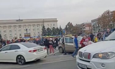 Crowd cheer and chant as they surround a car with Ukrainian soldiers in Kherson's main square on November 11. Ukrainian forces swept into the key city of Kherson on Friday as Russian troops retreated to the east.