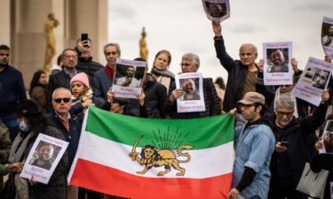 A group of protesters hold an Iranian flag and banners with the portrait of Toomaj Salehi in Paris on November 5