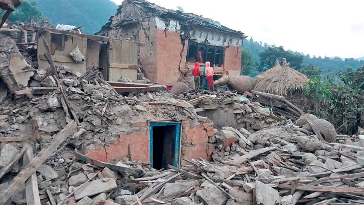 <i>Nepal Army/Reuters</i><br/>People outside the ruins of collapsed houses in the district of Doti after an earthquake struck Nepal on November 9.