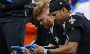 Andy Dalton (left) and backup quarterback Jameis Winston look at tablets during the second quarter against the Ravens on November 7.