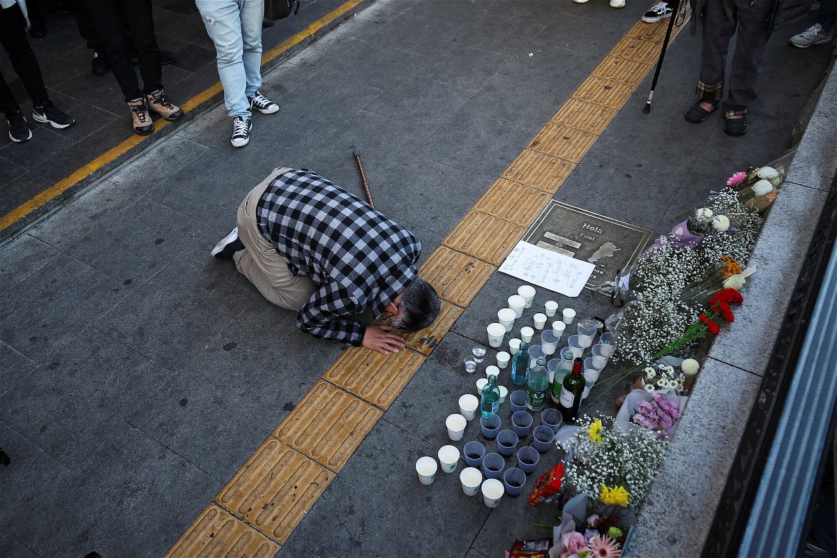 <i>Kim Hong-ji/Reuters</i><br/>A mourner pays tribute at a makeshift memorial near the site of the crush in Seoul on October 30.