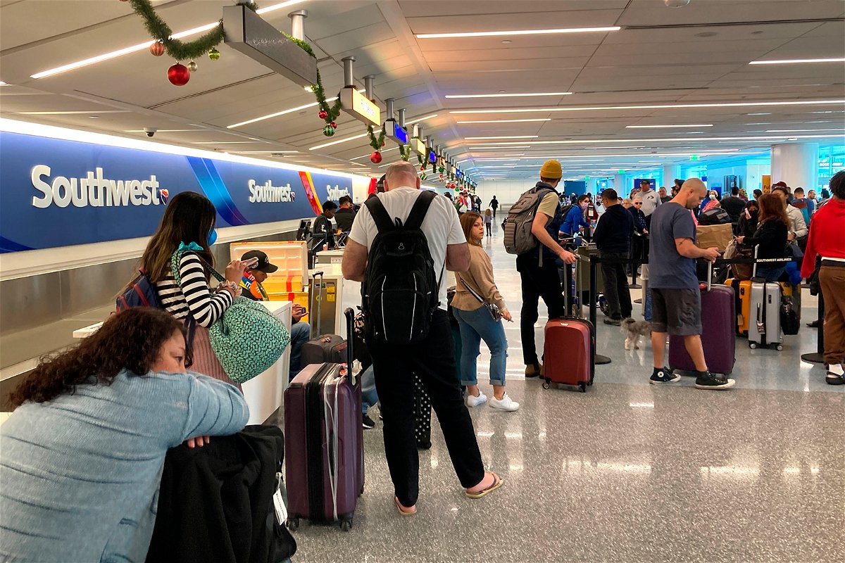 Travelers wait at a Southwest Airlines baggage counter to retrieve their bags after canceled flights at Los Angeles International Airport, Monday, Dec. 26, 2022, in Los Angeles. (AP Photo/Eugene Garcia)