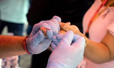 An experimental HIV vaccine has been found to induce broadly neutralizing antibodies among a small group of volunteers in a Phase 1 study. A health worker takes a blood sample from a woman to perform a rapid HIV test in Venezuela in 2021.