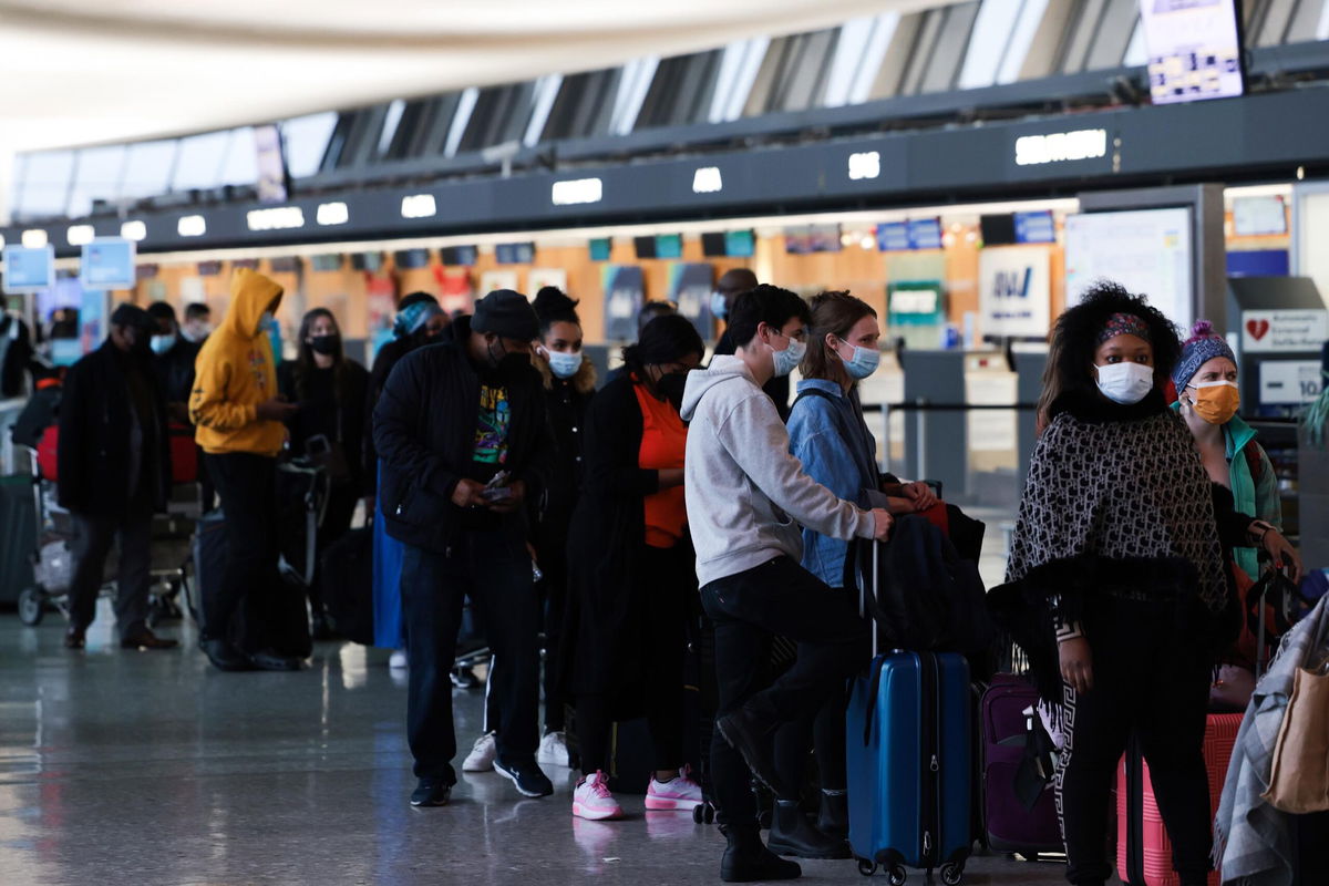 DULLES, VIRGINIA - DECEMBER 27: Passengers wait in line to check in for their flights at the Dulles International Airport on December 27, 2021 in Dulles, Virginia. According to media reports, at least 2,600 more flights were canceled Monday amid the surge in coronavirus cases, which have affected the staff within airlines. (Photo by Anna Moneymaker/Getty Images)