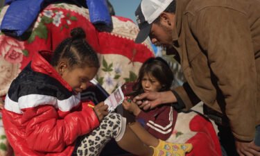 Francisco Mota plays with his children at an improvised camp of migrants