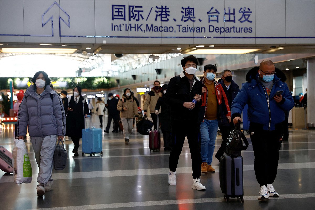 Travellers walk with their luggage at Beijing Capital International Airport, amid the coronavirus disease (COVID-19) outbreak in Beijing, China December 27, 2022. REUTERS/Tingshu Wang