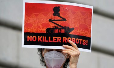 A woman demonstrates against about the use of robots by the San Francisco Police Department outside of City Hall Monday. San Francisco officials reverse course after public outcry against the policy.