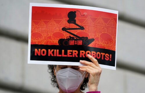 A woman demonstrates against about the use of robots by the San Francisco Police Department outside of City Hall Monday. San Francisco officials reverse course after public outcry against the policy.