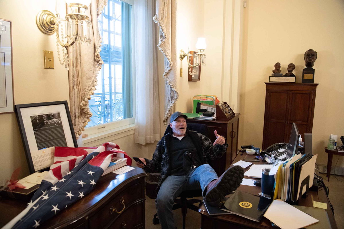 TOPSHOT - Richard Barnett, a supporter of US President Donald Trump sits inside the office of US Speaker of the House Nancy Pelosi as he protest inside the US Capitol in Washington, DC, January 6, 2021. - Demonstrators breeched security and entered the Capitol as Congress debated the a 2020 presidential election Electoral Vote Certification. (Photo by SAUL LOEB / AFP) (Photo by SAUL LOEB/AFP via Getty Images)