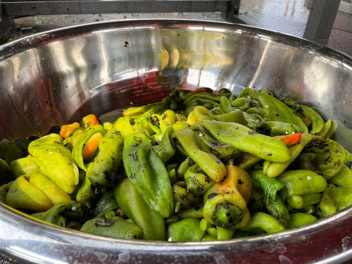 FILE - This July 12, 2021 image shows a large bowl of roasted green chile at a market in Hatch, N.M. Farmers say the season is shaping up to be a good one thanks to recent rain and cooler temperatures. There's nothing like the sweet smell of green chile roasting on an open flame. It permeates New Mexico every fall, wafting from roadside stands and grocery store parking lots, inducing immediate salivation and visions of mouth-watering culinary wonders laden with hot peppers. Democratic Sen. Bill Soules is proposing that roasted green chile become the official state aroma. (AP Photo/Susan Montoya Bryan, File)