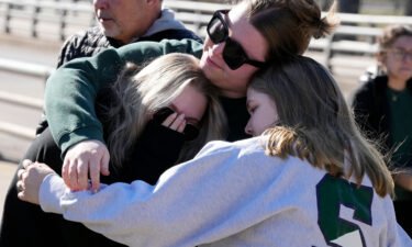 Michigan State University students embrace at The Rock on campus on February 14.