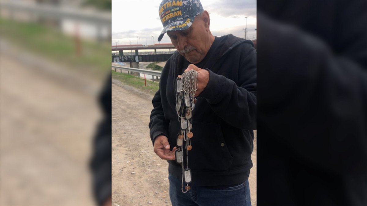 José Francisco Lopez holding dog tags of all the deported veterans who have died in Juárez