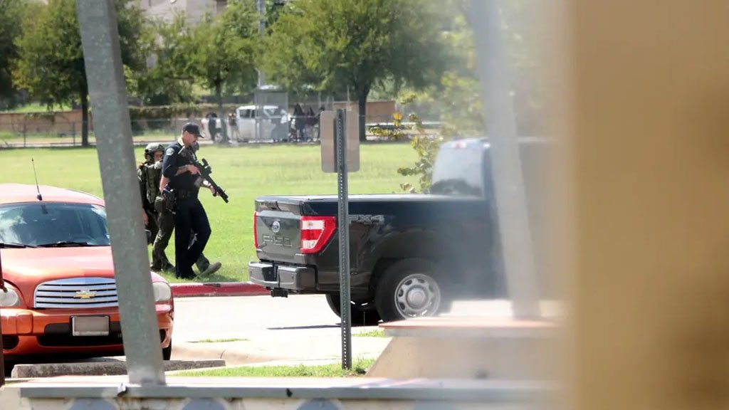 Law enforcement officers patrol outside the library of Akins Early College High School in Austin on Sept. 15, 2022. Authorities were called after a threat on social media was reported.