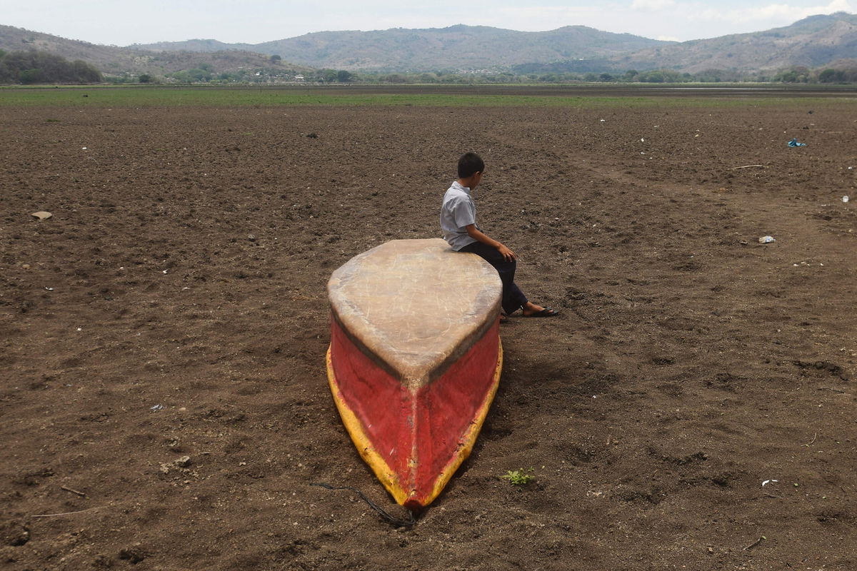 <i>Marvin Recinos/AFP/Getty Images</i><br/>A boy on an abandoned boat on what is left of Lake Atescatempa